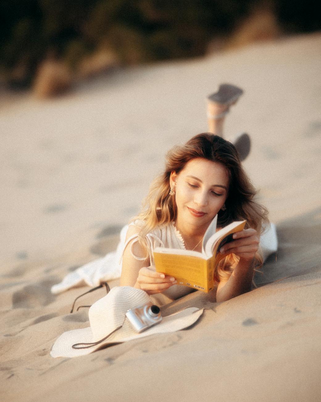 woman relaxing on beach reading a book