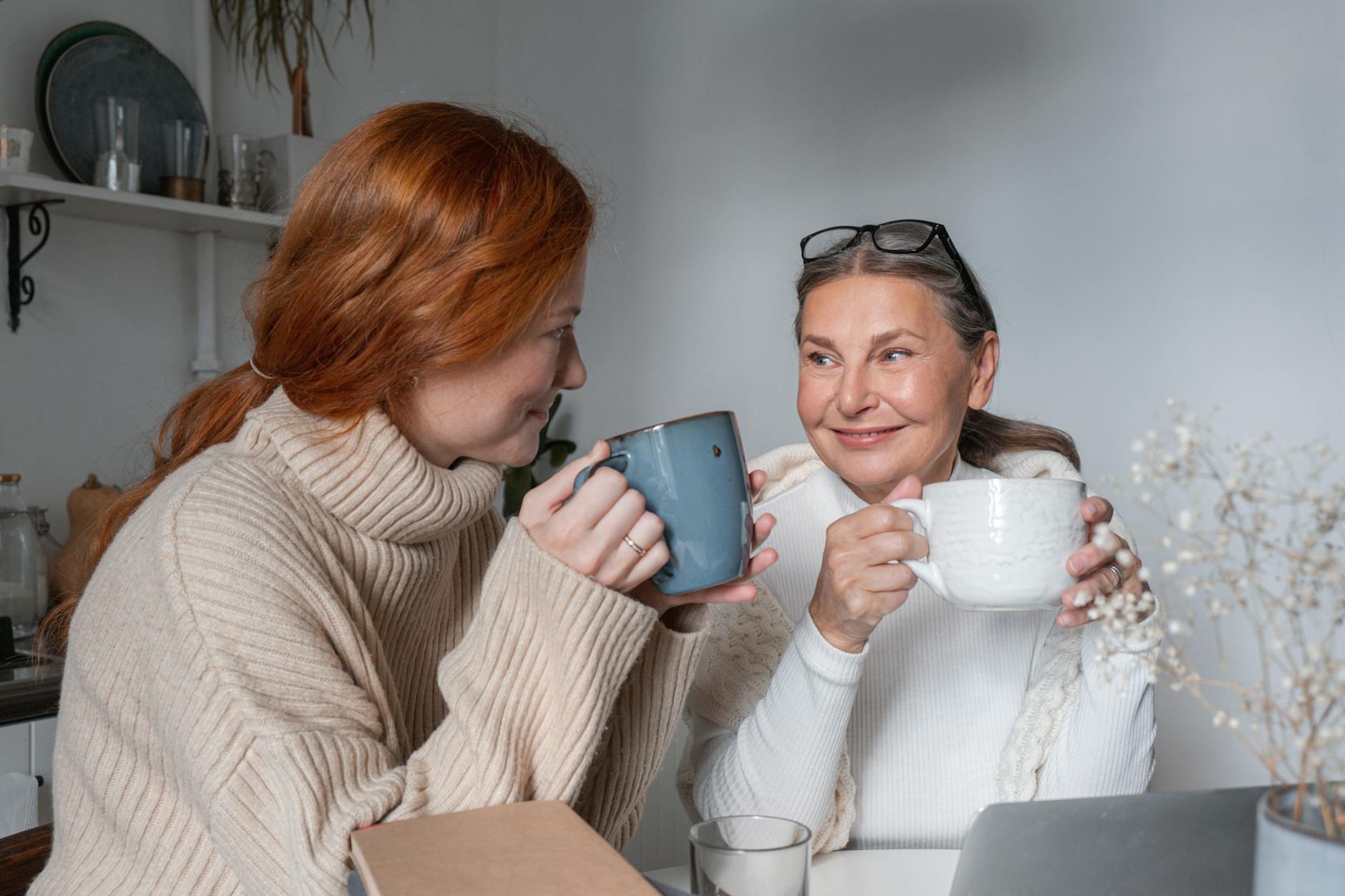 women sitting at a table and drinking coffee together